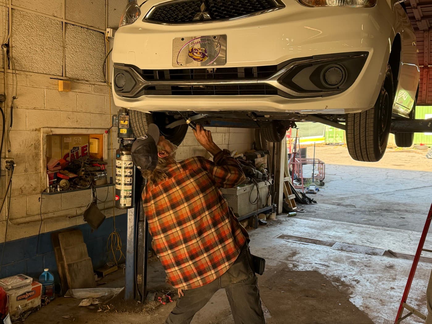 John Wanarski performing undercarriage inspection on lifted vehicle